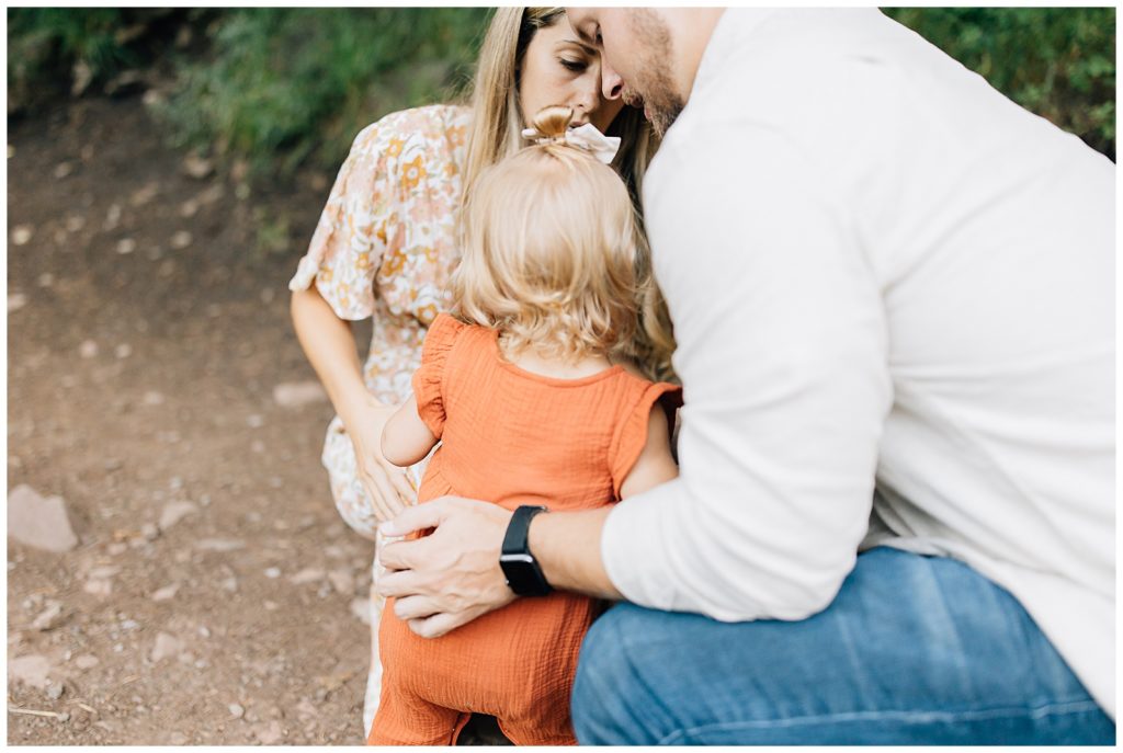 Understanding parents helping little girl through photo session. #saltlakecityphotography #familyphotos #outdoorphotography #fallcolors #orangejumper #shoulderseasonsession #bestphotos #beautifulfamily