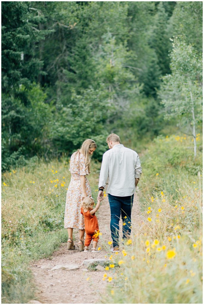 Beautiful family of four on a trail in the Utah mountains smiling and loving each other. #saltlakecityphotography #familyphotos #outdoorphotography #fallcolors #orangejumper #shoulderseasonsession #bestphotos #beautifulfamily