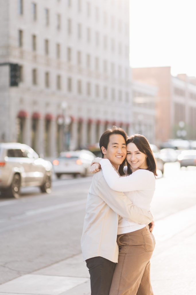 Engagement Portrait with a couple hugging in downtown Salt Lake City by Kailee Matsumura Photography. hip engagements modern #KaileeMatsumuraPhotography #KailleMatsumuraEngagements #SLCengagement #engaged #Utahphotographers #engagementphotography