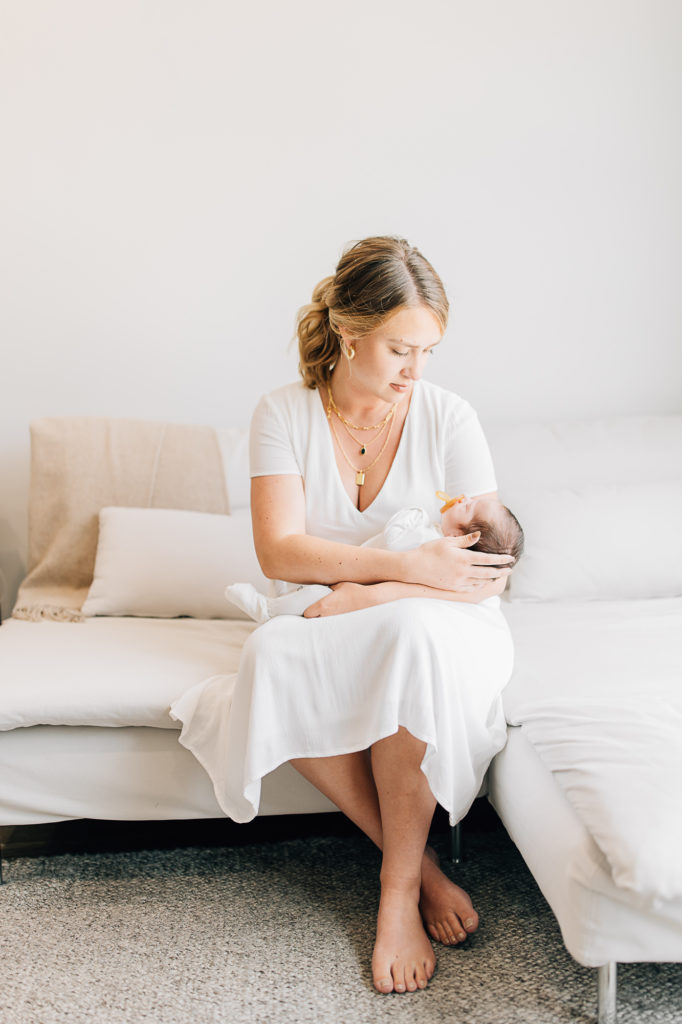 A bright portrait of a mother holding her newborn in her home by Kailee Matsumura Photography. new baby mommy pic #KaileeMatsumuraPhotography #SLCphotographers #motherhood #newbornphotography #Utahfamilyphotography #babyportraits