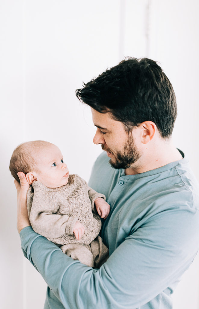 Newborn photographer Kailee Matsumura Photography captures a baby looking at his daddy. Utah newborns father and baby #KaileeMatsumuraPhotography #SLCphotographers #motherhood #newbornphotography #Utahfamilyphotography #babyportraits