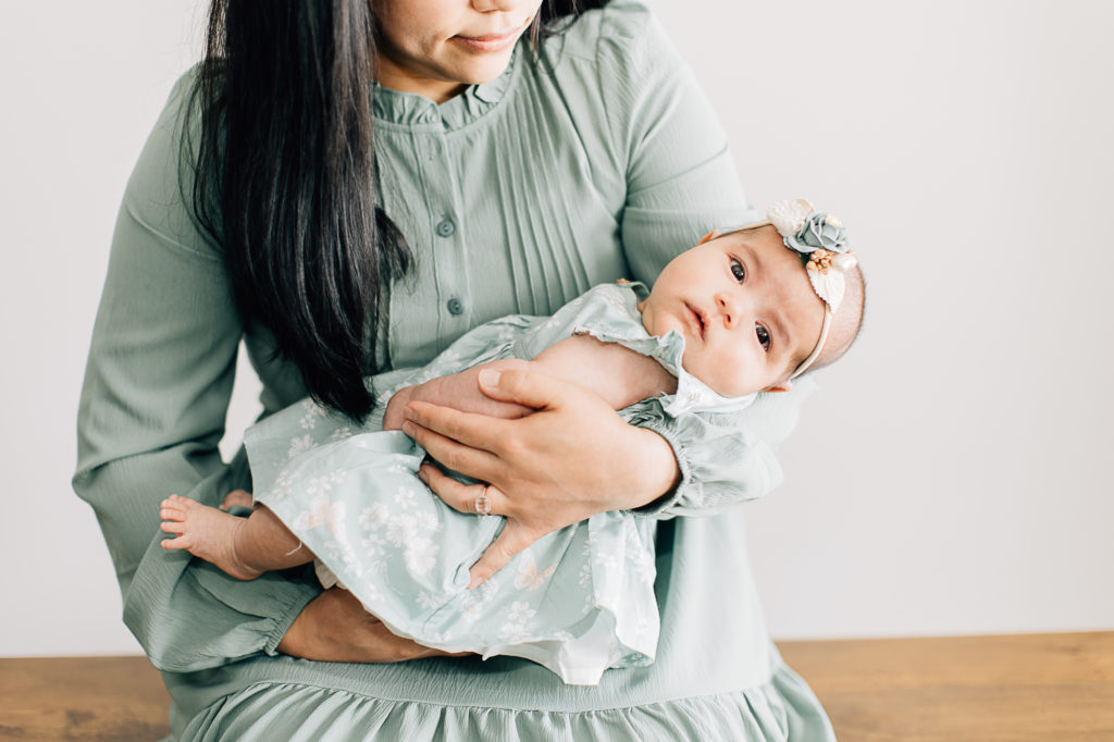 A mother holds her baby girl during a studio photo session with Kailee Matsumura Photography. motherhood portrait #KaileeMatsumuraPhotography #SLCphotographers #motherhood #newbornphotography #Utahfamilyphotography #babyportraits