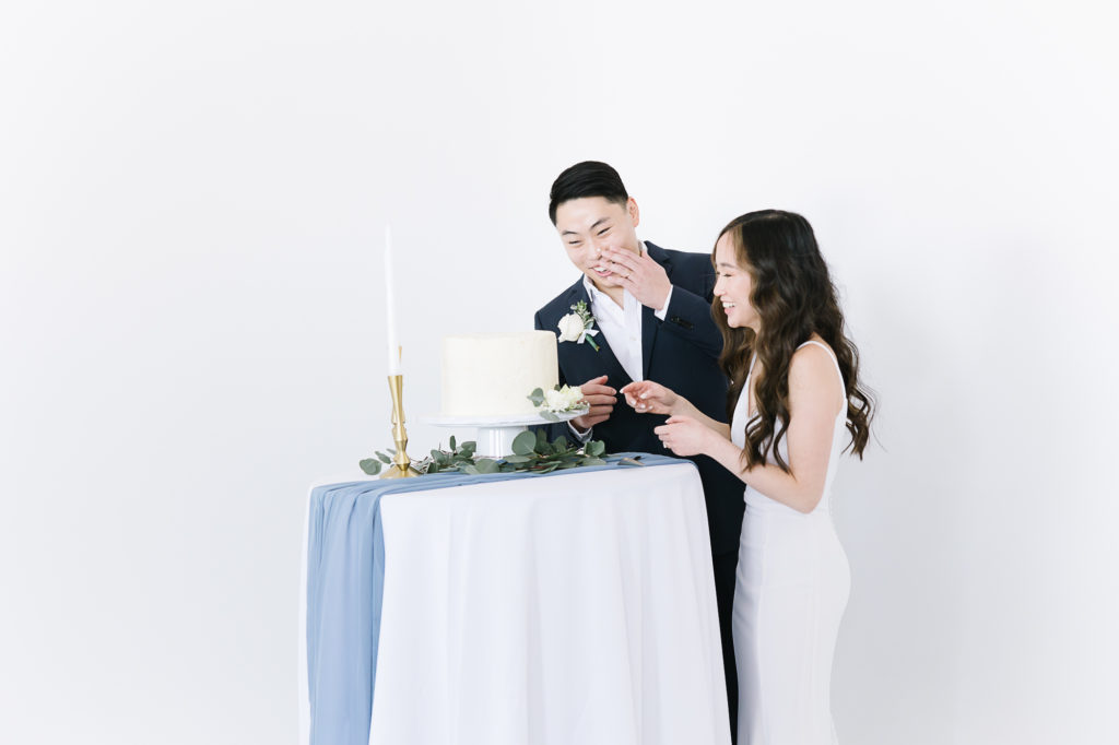 Cutting the cake- was a one level white cake decorated with greenery and with candlesticks. Bride smashed it in his face. #KaileeMatsumuraPhotography #KaileeMatsumuraWeddings #Studiowedding #UtahWedding #SLCwedding #SLCweddingphotographer
#WeddingphotographerinSLC