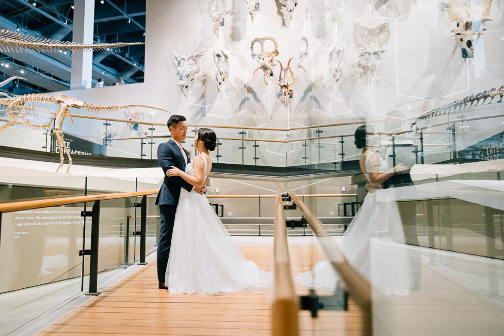 A bride and groom holding each other in their arms at the Natural History Museum by Kailee Matsumura Photography. NHMU wedding #KaileeMatsumuraPhotography #KaileeMatsumuraWeddings #NaturalHistoryMuseumofUtah #NHMUwedding #SLCweddings