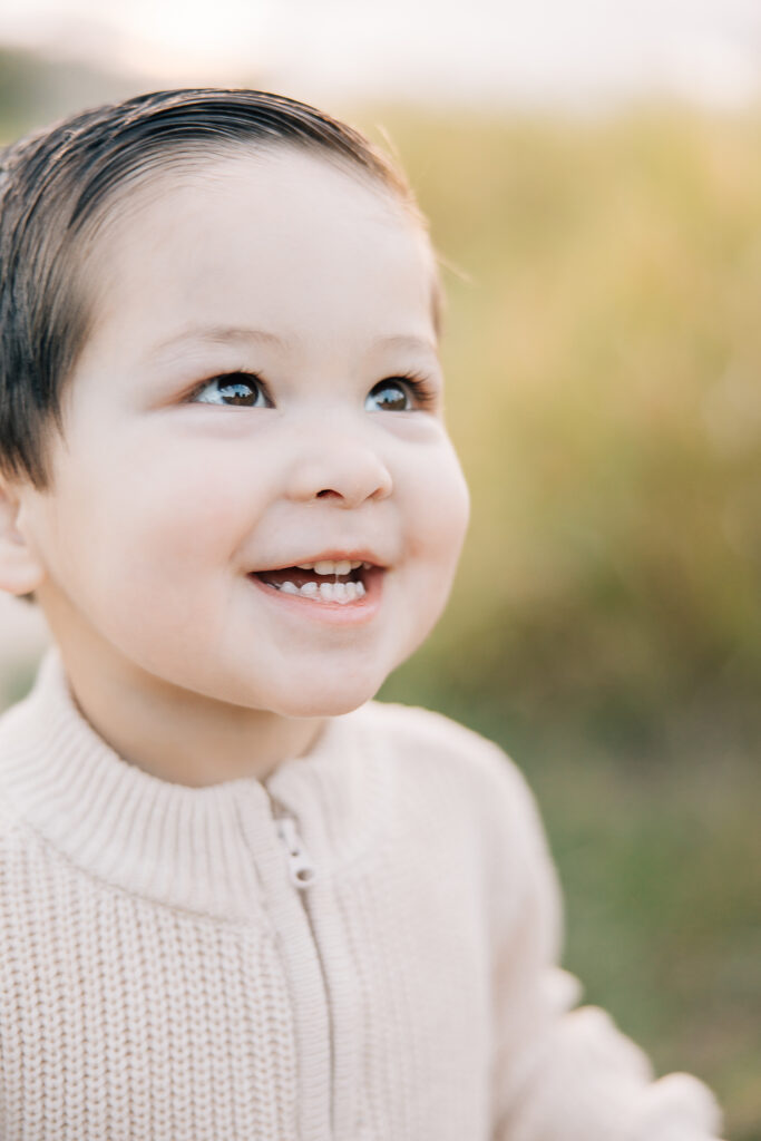 toddler boy smiles. Cream sweater for toddler in family photos. Memphis family photographer. 