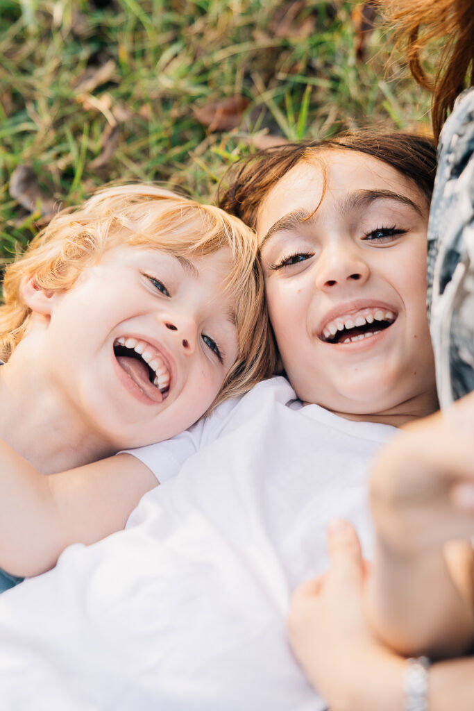 Two boys laughing in Memphis Tn during family photo session with Kailee Matsumura at Shelby Farms in Memphis, TN. 