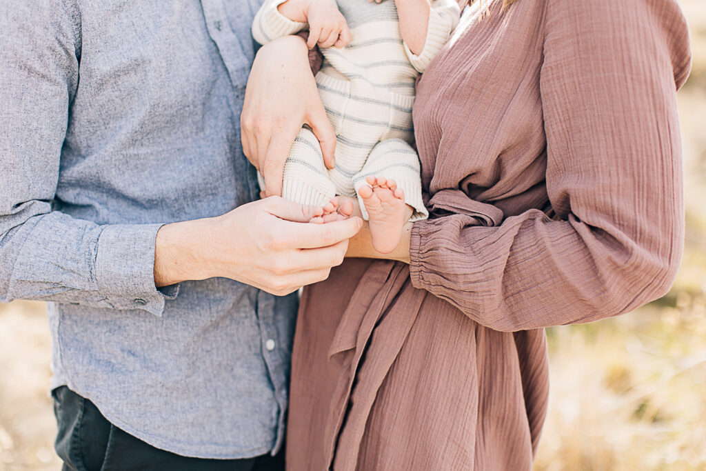 Memphis Newborn Photographer. Mom in pink casual dress. Family of three. Family with newborn family photos. Family photos with pink and blue as colors. 