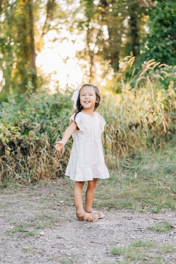Darling girl spins on a dirt path in a springtime dress during her family picture photoshoot in Memphis, Tennessee taken by Kailee Matsumura, professional family photographer in the Bartlett area #familyphotography #memphisfamilyphotographer #familypics