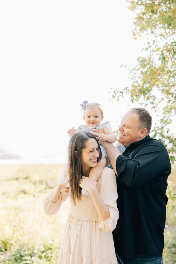 Young family poses for family pictures in Bartlett, Tennessee smiling faces captured by Kailee Matusmura in a professional family photo shoot just in time for holiday card season #familyphotos #familyoutfitinspo #tennesseephotographer