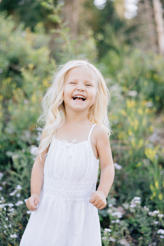 Toddler girl laughs big during her family photo session with Kailee Matsumura. Professional photography for families and children with neutral backgrounds so your family stands out #familyphotography #memphisfamilyphotographer #familypics