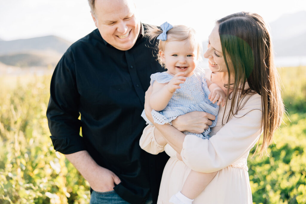 A sweet young family stands close together with mom and dad both smiling down at their tender baby daughter. Kailee Matsumura Photography has an eye for catching candid family moments.
#KaileeMatsumuraPhotography #FamilyPictures #TipsForFamilyPhotos #TennesseeFamilyPhotographer
