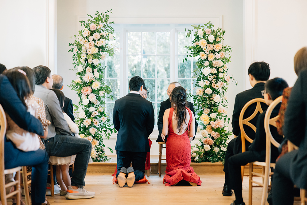 A unique wedding ceremony in Southaven, Mississippi, captures the bride in a red dress kneeling with the groom at the wedding ceremony. Wedding party ceremony traditions culture special unique red wedding dress #missippiweddingphotographer #tennesseweddingphotographer #KaileeMatsumura #Bartletttennesse #southhavenmissippi
