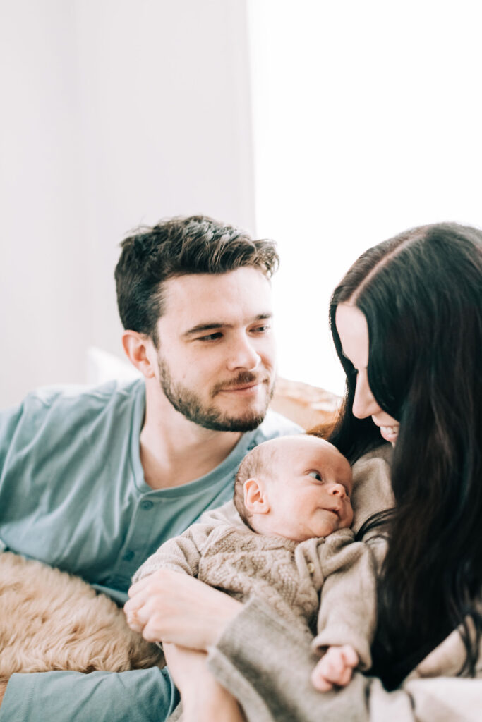 Kailee Matsumura captures a candid shot of a husband gazing lovingly at his wife and their new son during a photo session in Germantown, TN by family photographer, Kailee Matsumura. Candid shots Pet family photography #familypetphotography #tennesseenewbornphotographer #kaileematsumuraphotography #petsofinstagram #tennesseefamilyphotographer #mississippiphotographer  