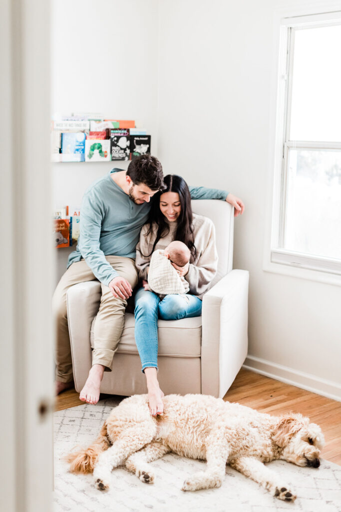 Kailee Matsumura, a Memphis-based photographer, captures a young family snuggling their newborn son while their dog lounges comfortably at their feet. Pet family photography Olive Branch Mississippi #familypetphotography #tennesseenewbornphotographer #kaileematsumuraphotography #petsofinstagram