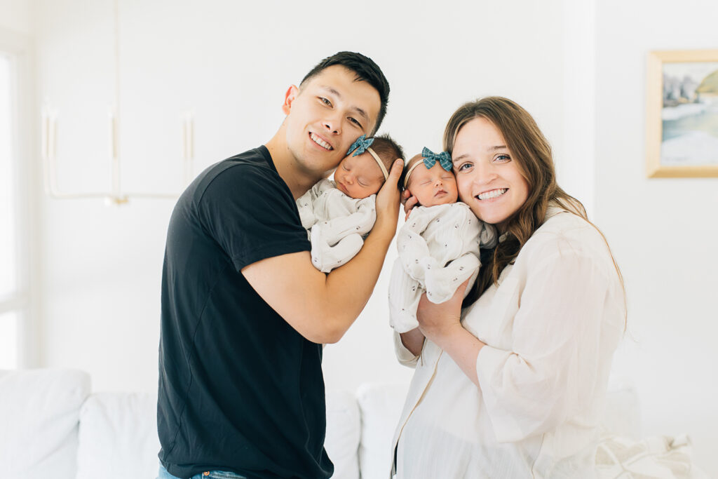 A new young family poses with their twin girls in their own home after having a C-section. Germantown Newborn Photographer, Kailee Matsumura captures this moment. 