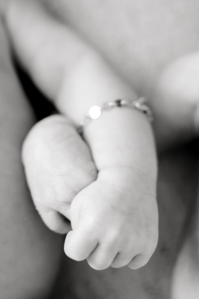 twin girls hold hands during their newborn session with Germantown Newborn Photographer, Kailee Matsumura. 