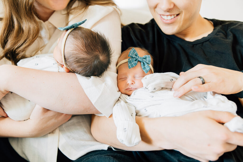 A mom and dad of two newborn twin girls during their newborn photoshoot in their home with Memphis Newborn Photographer, Kailee Matsumura.