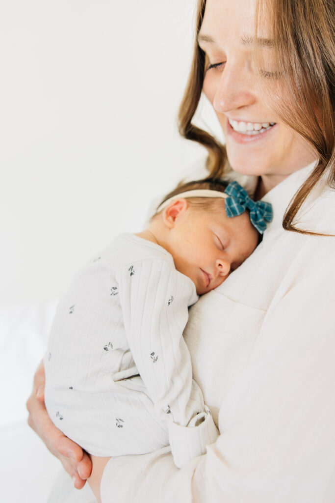 Baby sleeps on moms chest during newborn session. 