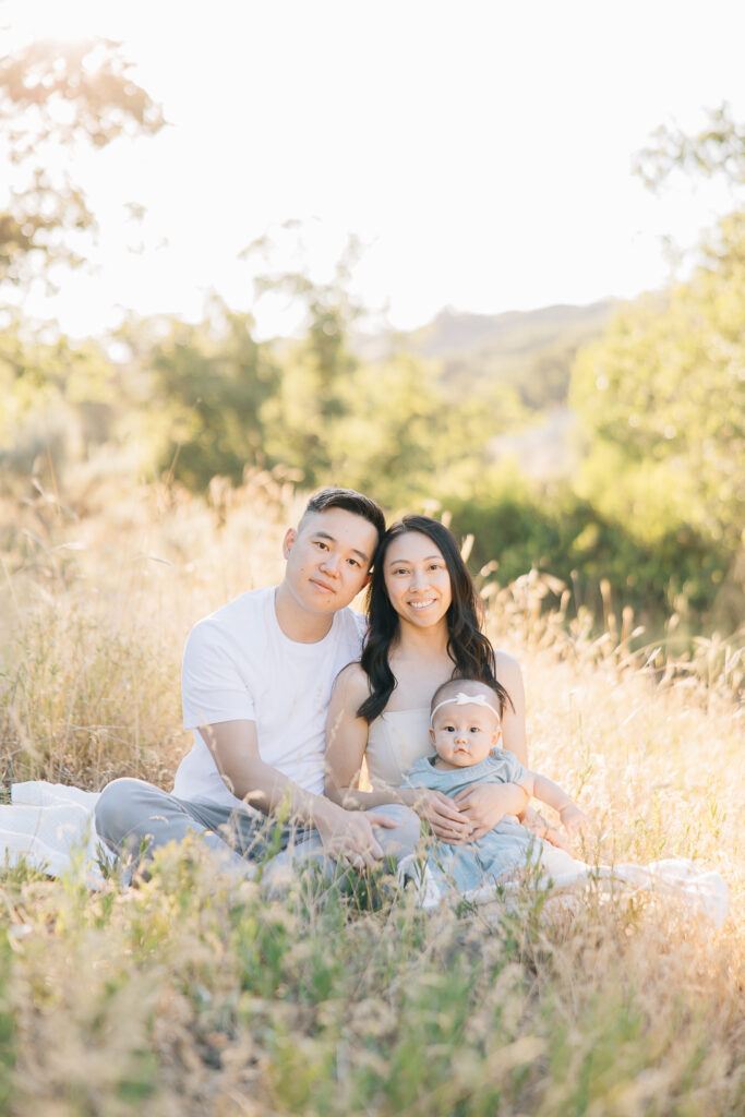 Parents and newborn all look straight into the camera during their Germantown newborn photography session. Summer outfit inspo.