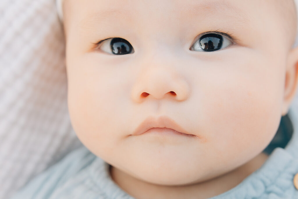 Closeup of baby eyes with reflection in her eyes. Close up of baby nose and lips and perfect baby skin during newborn session in Germantown, TN. 