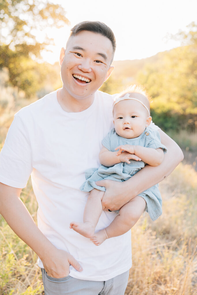 Dad smiles with newborn in his arms during this outdoor newborn session in Germantown, TN.