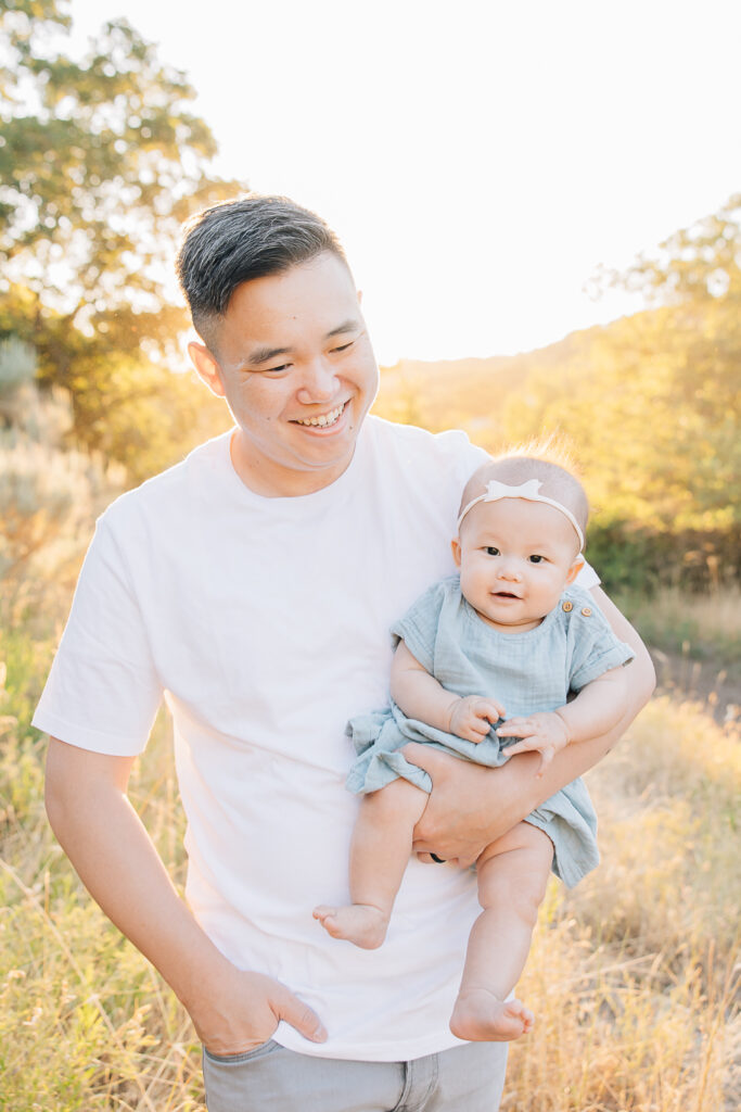 Dad walks with newborn daughter in outdoor newborn session in Germantown, TN with Germantown Newborn Photographer, Kailee Matsumura. Summer outfit Inspo. Shelby Farms newborn photos. Shelby Farms Family photographer. 