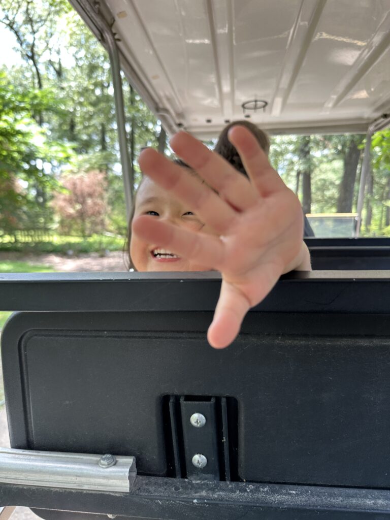 Little girl riding a golf cart around the Memphis Botanical Gardens. 